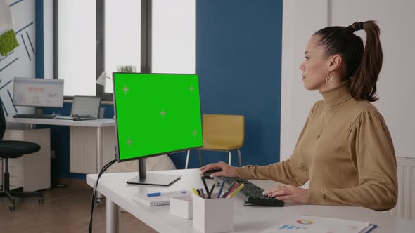 Worker Using Monitor with Green Screen in Business Office