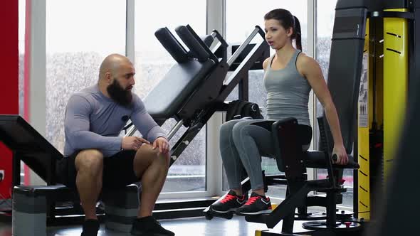 Personal Trainer Consulting Female Gym Visitor During Workout, Active Lifestyle