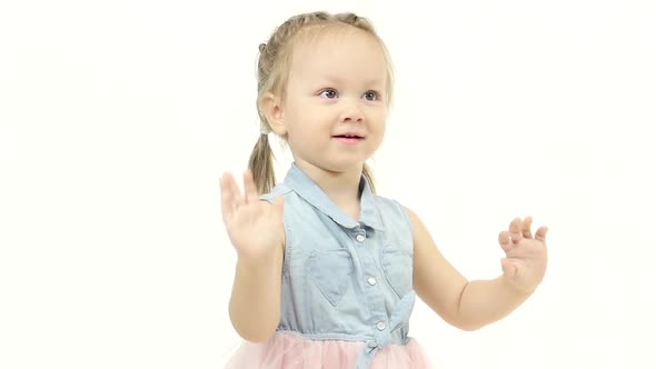 Little Girl Claps Her Hands in Fun. White Background. Slow Motion