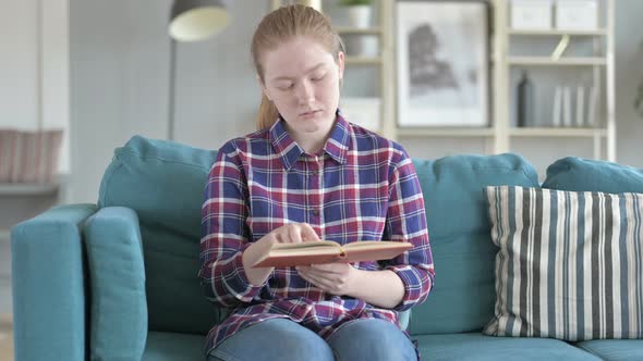 Young Woman Sitting on Couch And Reading