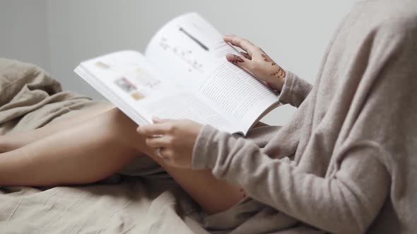 a Woman with a Mandala Watching a Newspaper, She Flips Through Pages