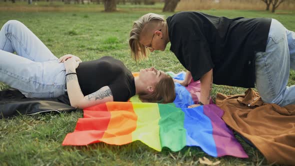Dolly in Real LGBT Couple Kissing Lying on Rainbow Flag