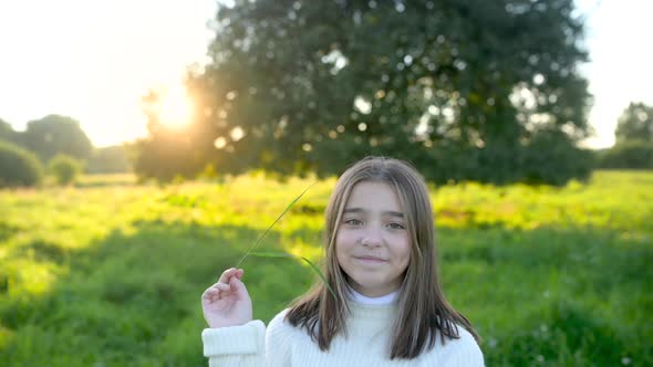 Portrait of a happy girl in a field on a summer evening.