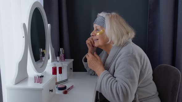 Old Senior Woman Grandmother Taking Care of Skin Near Eyes and Wrinkles, Putting Makeup on at Home