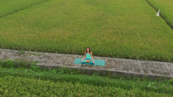 Slowmotion Aerial Shot of a Young Woman Doing Meditation for Muladhara Chakra in a Balinese Way