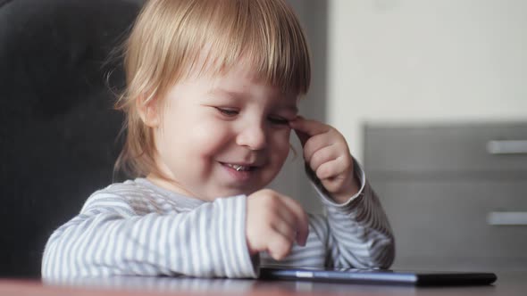 Portrait Funny Little Baby Boy Smiling Looking at the Camera and Using a Digital Tablet