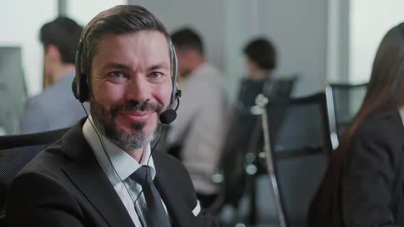 Portrait of Handsome Happy and Man Smiling and Looking at Camera While Working in Call Center