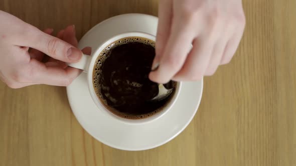Delicious and Flavored Hot Coffee Rotating in White Cup After It Was Stirred