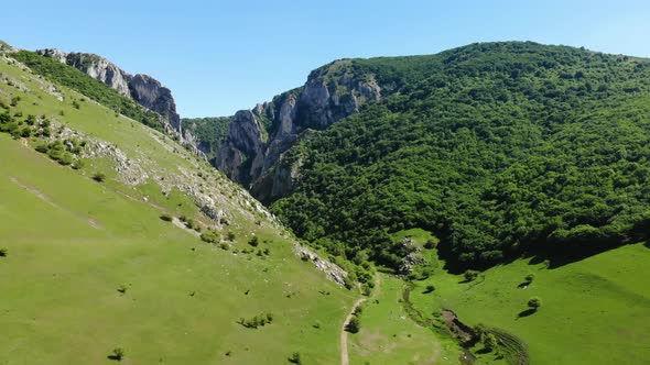 Wide aerial view of the landscape surrounding Turda Gorge. Scenic river and valley lead toward the n