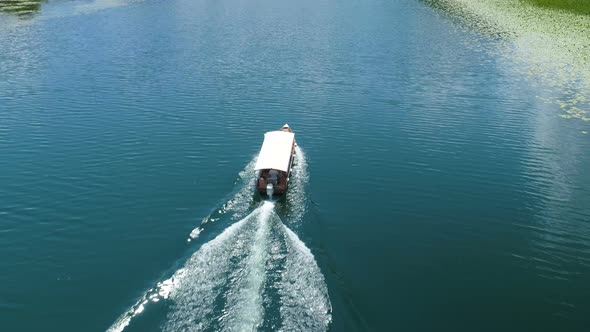 Motor Boat Floats on a Crnojevica River Framed By Water Lilies