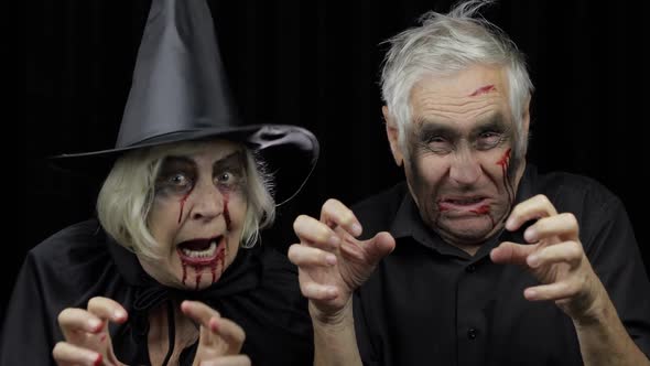 Elderly Man and Woman in Halloween Costumes. Witch and Zombie