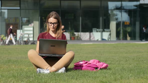 Woman Uses Laptop on Grass