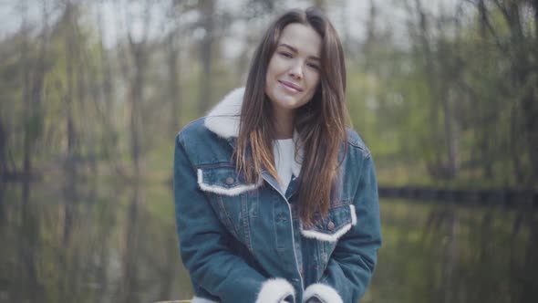 Portrait of Graceful Young Smiling Woman Looking in the Camera. Beautiful Landscape, River on