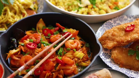 Asian Food Served. Plates, Pans and Bowls Full of Noodles Chicken Stir Fry and Vegetables