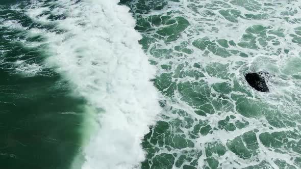 Majestic ocean waves and Klayar beach, East Java Indonesia, aerial tilt up