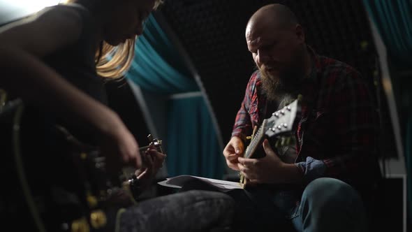 Young Beautiful Girl in Lesson with Experienced Guitarist in Studio