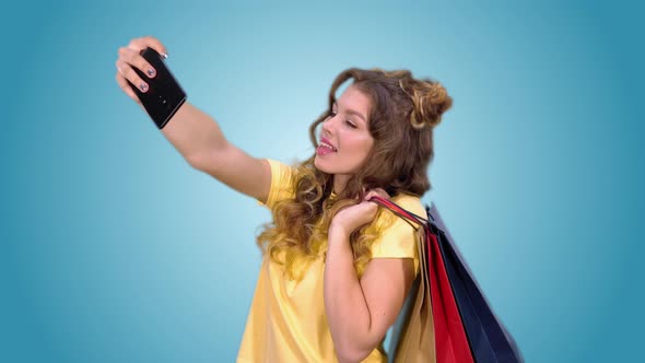 Beautiful Young Girl in a Yellow Tshirt After Shopping Makes Selfie and Smiling