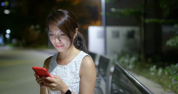 Woman use of mobile phone at outdoor in the evening