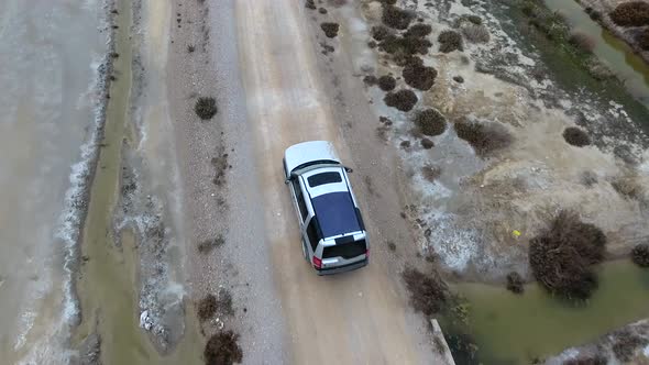 Car Going on Dirt Road on Arid Barren Desert