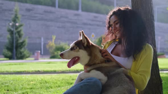 Girl Spending Lovely Summer Day with Dog Outdoors