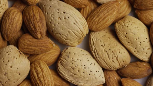 Cinematic, rotating shot of almonds on a white surface