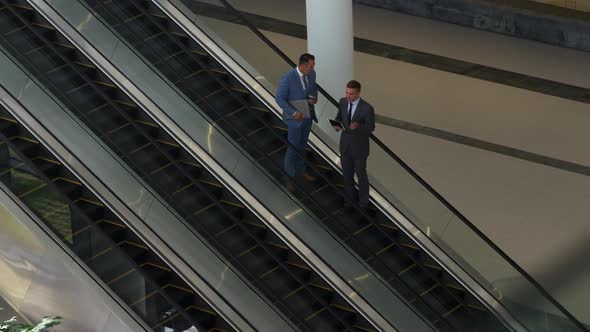 Businessmen on an escalator in a modern building