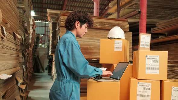 One female worker scan bar codes to check orders at parcels warehouse factory.