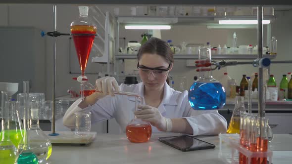 Professional Scientist Pouring Liquid To Glass Bulb alt
