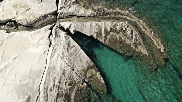 Incredibly crystal-clear, turquoise blue waters gently rolling onto white rocks in the Mediterranean