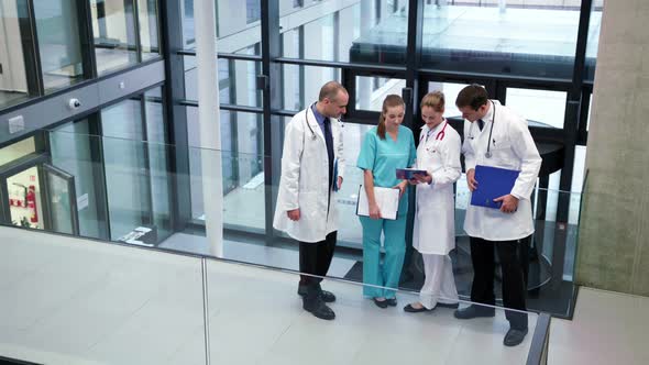 Doctors interacting with each other in corridor