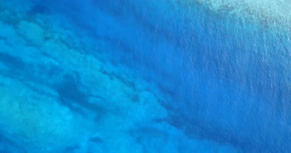 Tropical fly over tourism shot of a white paradise beach and aqua blue water background in vibrant 4