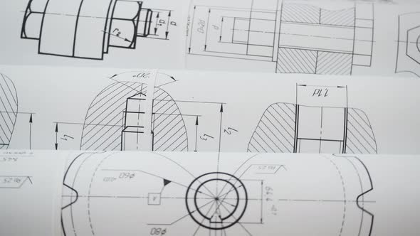 paper engineering drawings of industrial parts and mechanisms