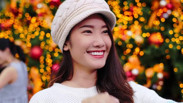 Happy young asian woman taking a selfie photo near christmas tree