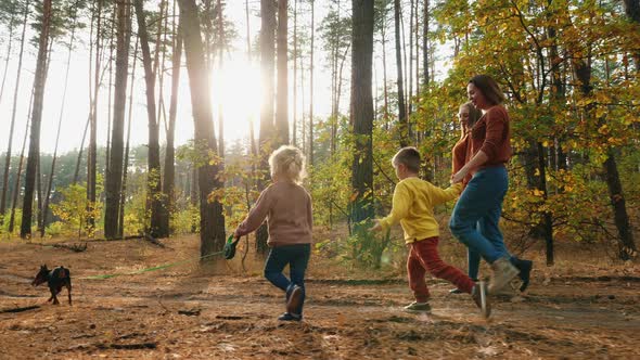 Family with Children and Dog Walking in the Woods