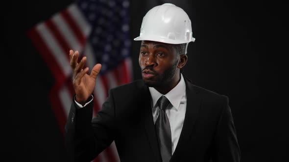 Enthusiastic African American Man Taking Off White Hard Hat Speaking to Public at News Conference