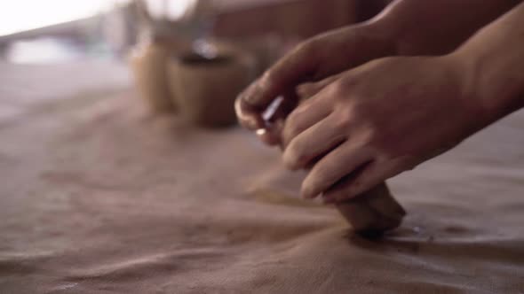 Female Hands of a Potter Knead and Form a Soft Wet Piece of White Clay