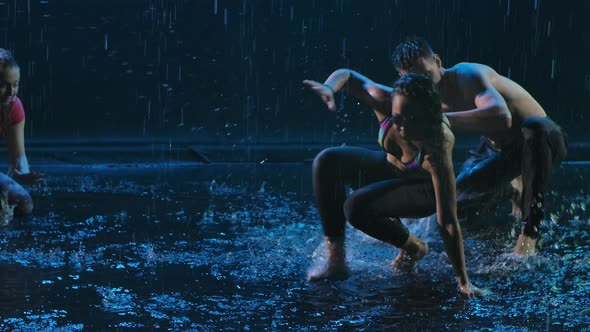 A Group of Professional Dancers Practice Capoeira in the Dark in the Rain. Afro Brazilian Martial