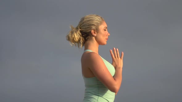 A young attractive woman doing yoga on the beach.