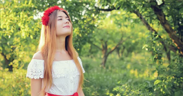 Pretty Girl Walks in the Park and Enjoys Nature She is Happy