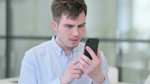 Portrait of Young Man Loss on Smartphone