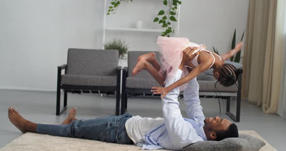 Caring Loving Father Afro American Man Plays with Little Funny Daughter Girl Child in Pink Dress