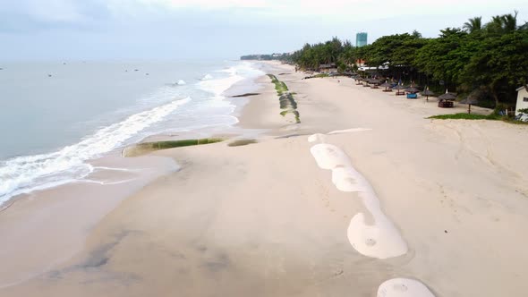 Aerial, beach in Vietnam with barriers to prevent climate change sea level rise