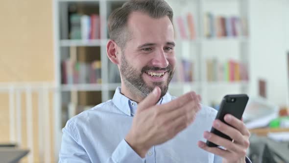 Portrait of Young Man Celebrating Success on Smartphone