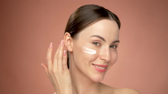 Woman Applying Cosmetic Product on Face