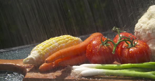 Washing a colorful display of garden fresh, ripe vegetables in the sun