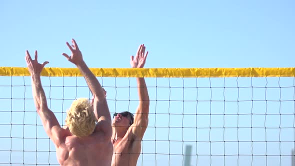 Men playing beach volleyball.