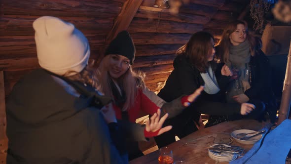 Happy Young Women Having Fun in the Wooden Cottage and Celebrating New Year