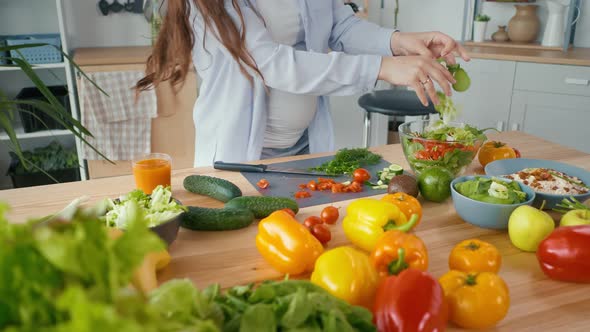 Pregnant Woman Preparing Organic Healthy Food Slicing Vegetables for Salad