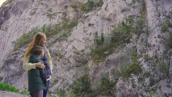A Woman and Her Son Stand at the Roadside Observing a Magnificent Canyon of the Moracha River