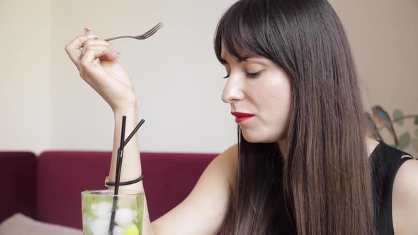 Side View of Young Brunette Eating Delicious Cake in Cafe